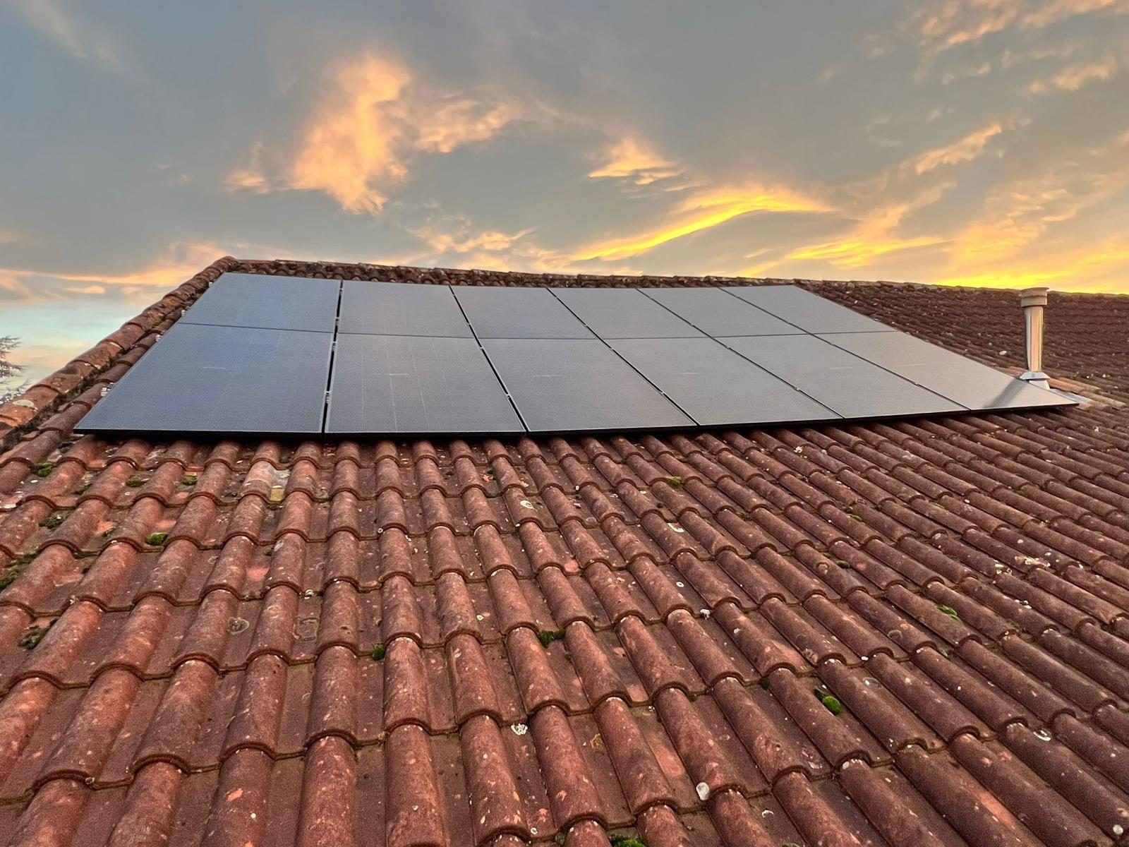 Panneaux solaires installés sur toiture en tuiles au coucher du soleil par Nrgie Conseil
