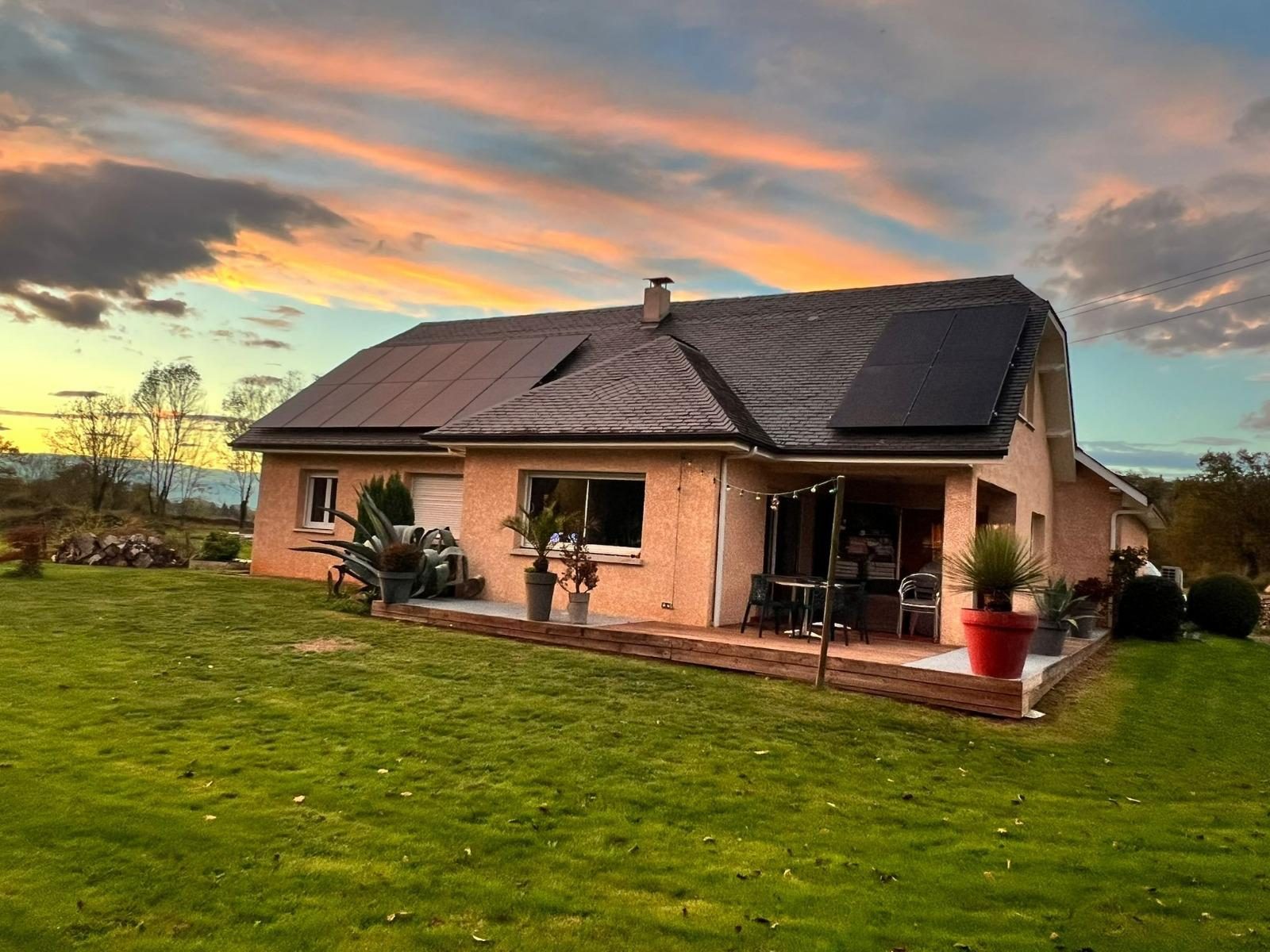 Maison équipée de panneaux solaires par Nrgie Conseil au coucher du soleil