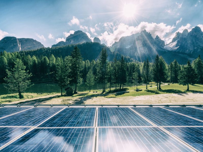 Solar cell panel in country landscape against sunny sky and mountain backgrounds. Solar power is the innovation for sustainability of world energy. Sustainable resources.