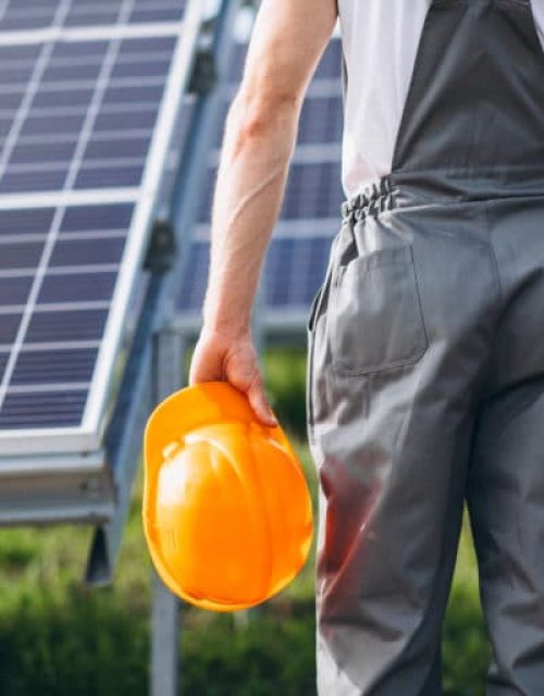 Man worker in the firld by the solar panels